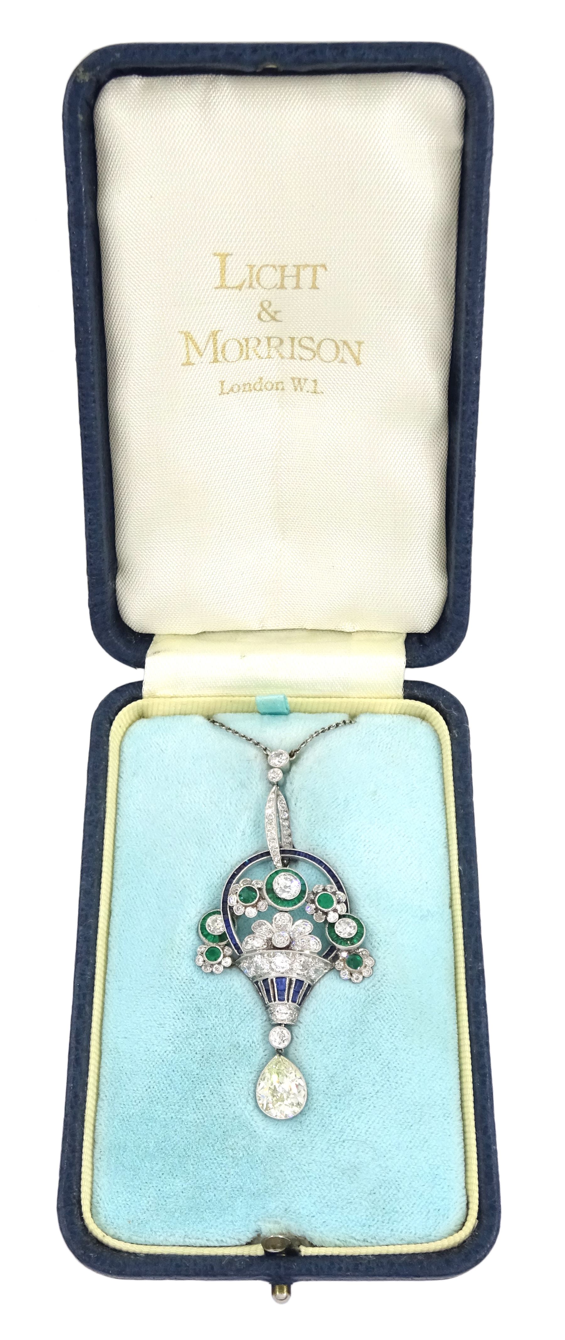 Art Deco platinum milgrain set diamond, emerald and sapphire flower basket pendant necklace, the basket set with old cut diamonds, calibre cut sapphires and emeralds, diamonds approx 2.00 carat, suspending a single pear cut diamond of approx 2.05 carat, on a platinum trace link chain necklace, stamped Plat, circa 1915-1920, in fitted box by Licht & Morrison, London