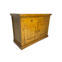 Solid light oak sideboard, rectangular top fitted with two drawers and two cupboards with panelled fronts, on plinth base
