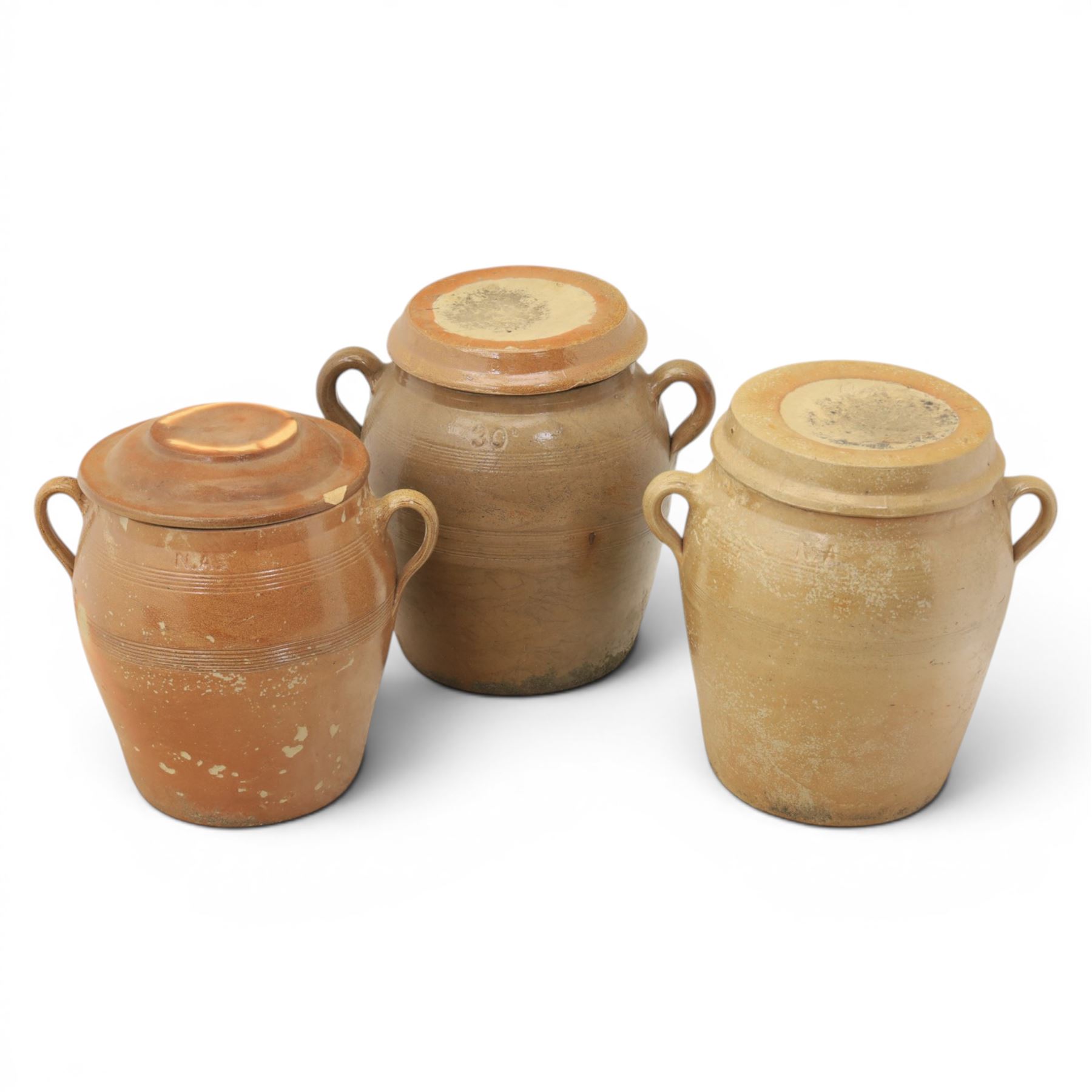 Three large 20th century Spanish stoneware confit pots and covers, each of ovoid form with twin loop handles to shoulders, and lift off covers, tallest example H43.5cm