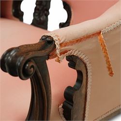 Mid-19th century carved rosewood double-ended settee, double spoon back with central splat carved with C-scrolls and shells, upholstered in pink buttoned fabric, scroll carved arm terminals on shaped supports, on leaf and flower head carved cabriole feet 