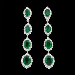 Pair of 18ct white gold graduating emerald and diamond pendant stud earrings, oval cut emerald and round brilliant cut cluster, suspending a single round brilliant cut diamond and three further emerald and diamond clusters, stamped, total emerald weight approx 8.65 carat, total diamond weight approx 3.30 carat