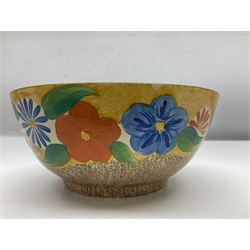 1930s Clarice Cliff Bizarre for Newport Pottery bowl, decorated in the Canterbury Bells pattern, the exterior painted with stylised flowers in blue, yellow and orange amongst foliage upon a brown and yellow Cafe au Lait stippled ground, with black printed mark beneath, D18cm