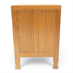 Mouseman - adzed and panelled oak bedside cupboard of small proportions, raised back over rectangular canted top, fitted with single panelled cupboard door with chamfered rails and turned knob handle, enclosing single shelf, raised on octagonal feet,  carved with mouse signature, by the workshop of Robert Thompson of Kilburn