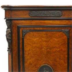 Lamb of Manchester (est. 1843) - Victorian Aesthetic Movement inlaid figured and burr walnut inverted-breakfront credenza, the shaped rectangular top with ebony banding and boxwood stringing, the frieze applied with bronze mounts decorated with foliate and scroll motifs, fitted with central glazed door flanked by panelled doors with central oval metal plaques depicting Classical Muses with lyre, the flanking canted uprights applied with caryatid maidens holding torches, acanthus terminal over skirted base