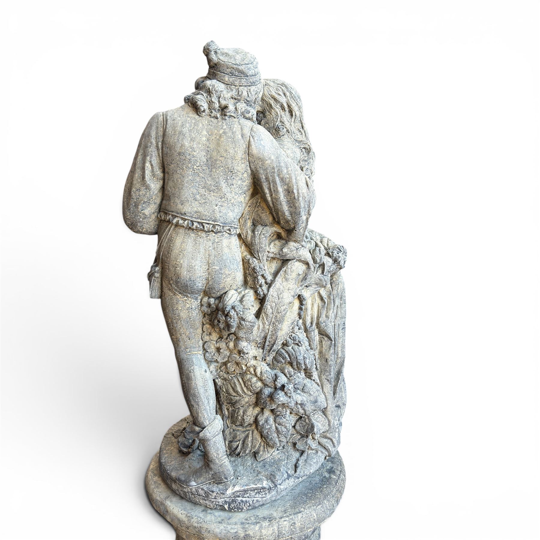 Composite garden statue group of Romeo and Juliet embracing, the couple adorned in Medieval dress standing on a naturalistic base with fallen flowers, raised on a Neoclassical fluted pedestal with Anthemion leaf motifs