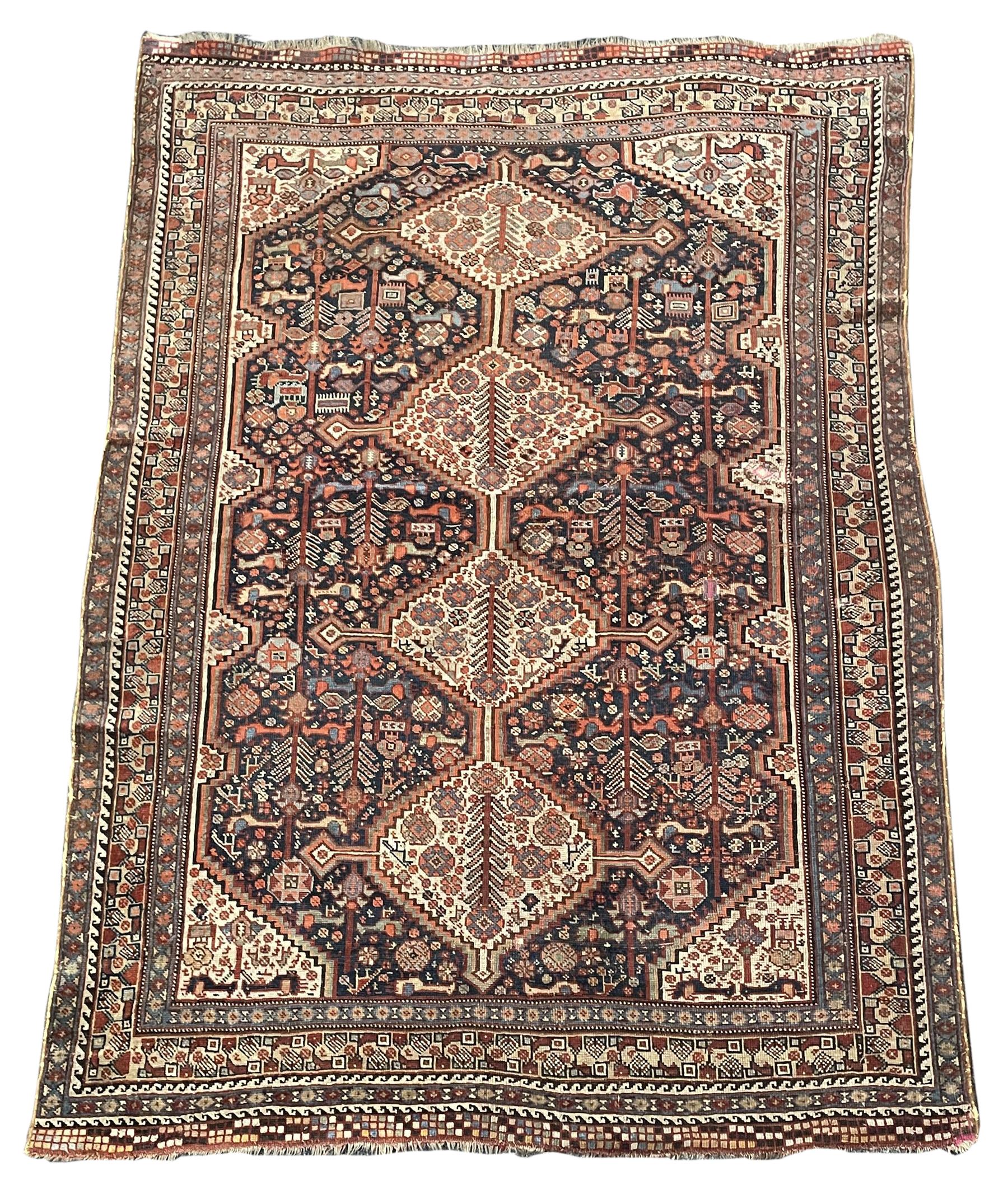 Persian rug, blue ground field decorated with quadruple pole medallion surrounded by animal motifs and stylised flower heads, multiple band border