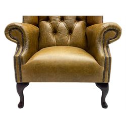 Georgian design wingback armchair, high back with shaped cresting rail over scrolled arms, upholstered in buttoned tan leather with stud-work border, raised on cabriole supports