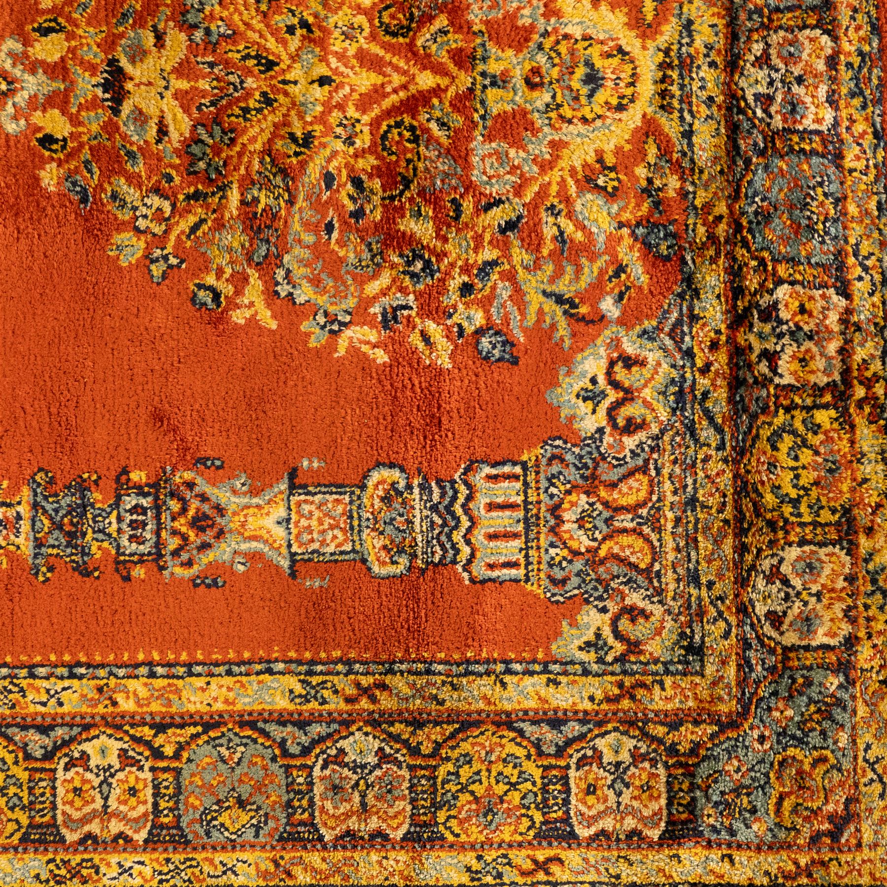 Persian Kashan prayer rug, rust red field with mihrab arch design, suspended floral hanging lamps, and a central flowering vase framed by columnar supports enclosed by palmette and meandering vine border