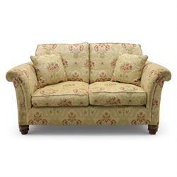 Late 20th century two seat sofa upholstered in floral beige and red fabric, turned supports 