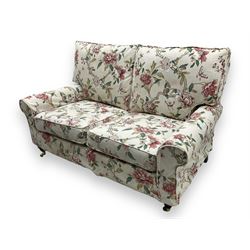 Steed Upholstery - 'Knightsbridge' two seater sofa, upholstered in cream fabric with pink and green floral design, loose back and seat cushions, raised on mahogany supports with brass castors