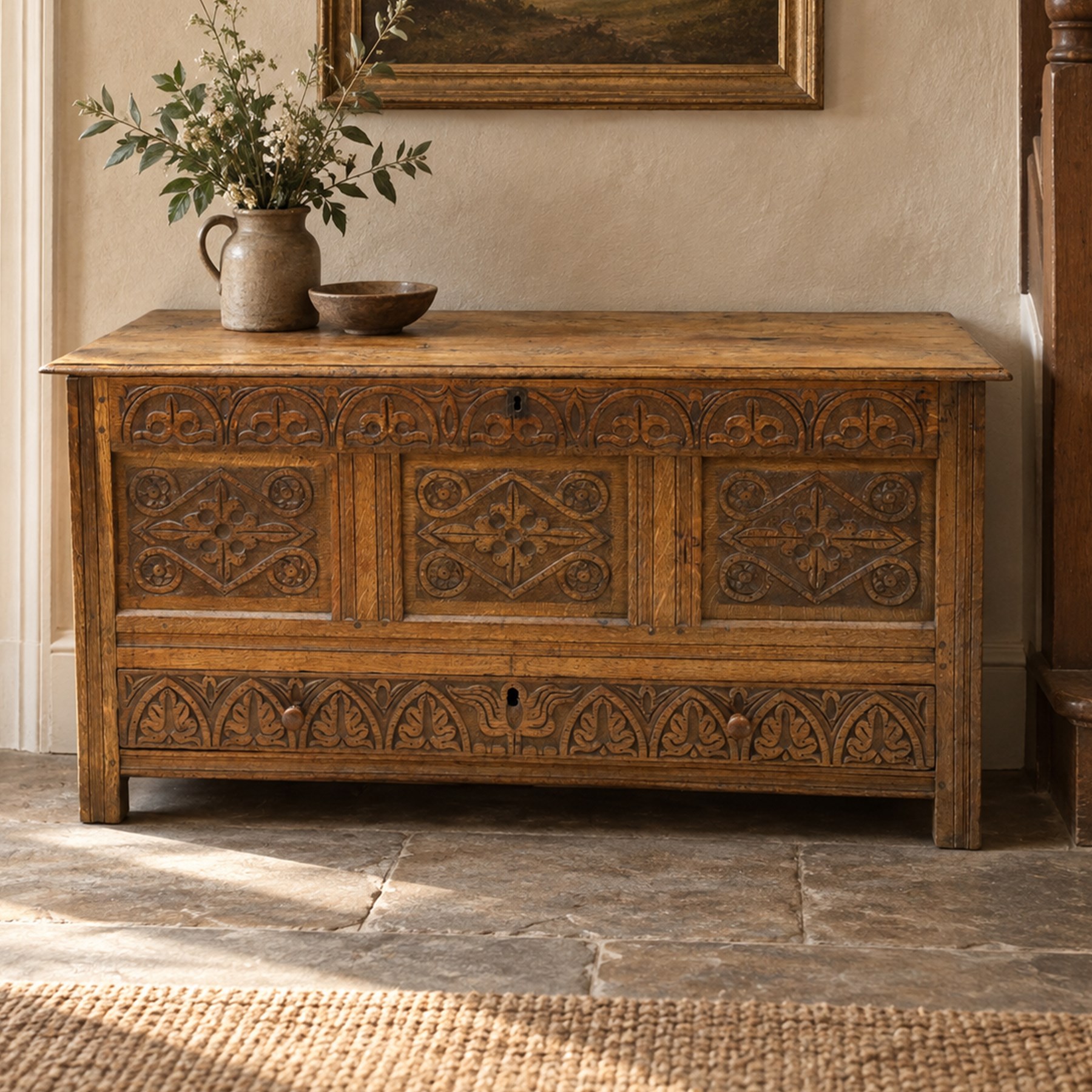 18th century carved oak coffer, rectangular hinged top over a lunette-carved frieze and tracery-style carved triple panelled front, the lower rail carved with repeating anthemion motifs, on square feet
