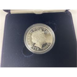 Queen Elizabeth II 2000 'The Queen Mother' silver proof five pound coin, 2000 'Millennium' silver proof five pounds, 2007 'Scouts' silver proof fifty pence, Tristan Da Cunha 2014 9ct gold 1 gram gold one crown coin, all cased with certificates and a 'Prince Charles 60th Birthday Commemorative Coin Cover' containing a 2008 silver proof five pound coin in folder (5)