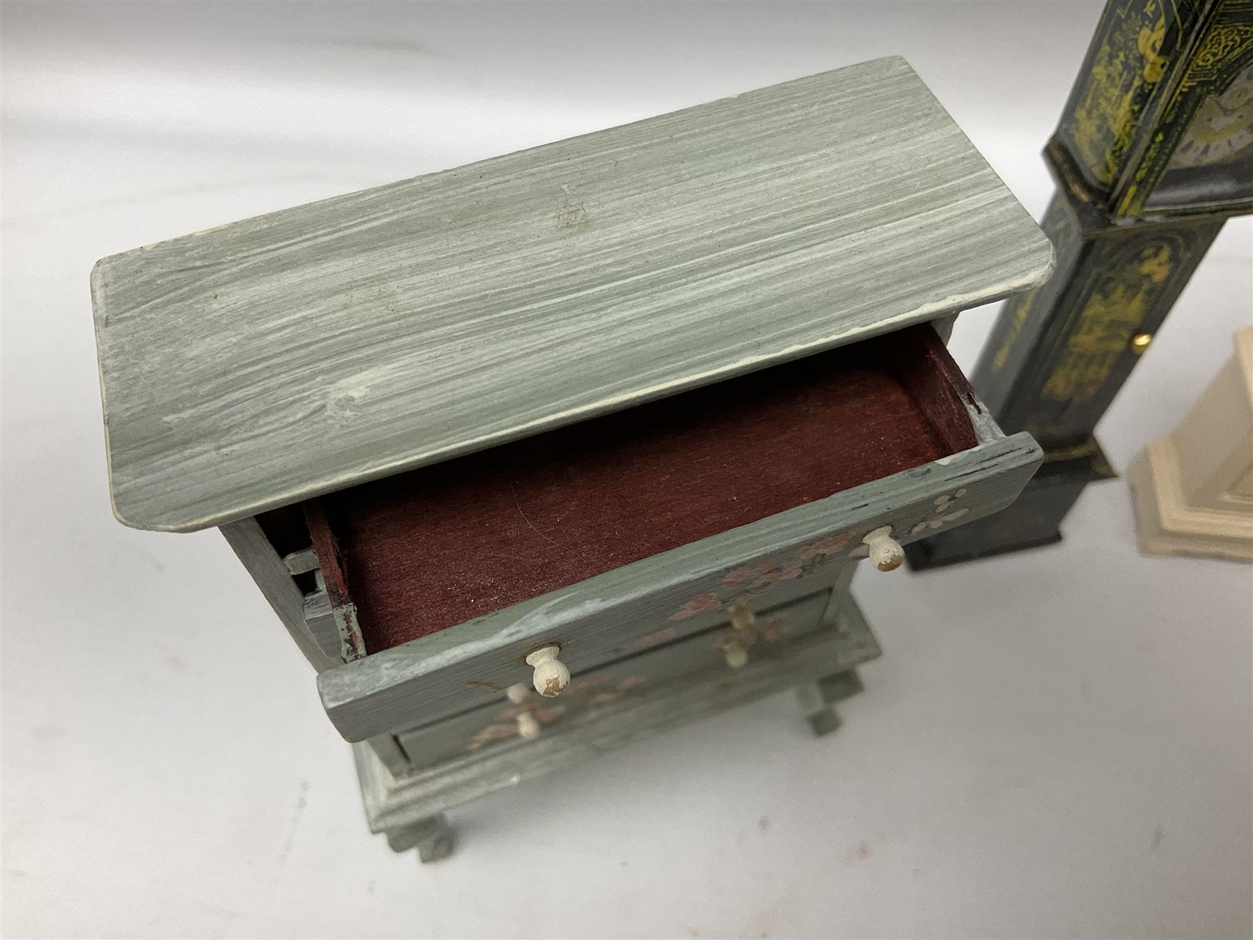 Collection of miniature dolls house furniture, to include five drawer chest painted with blossom, cream and gilt double door mirrored wardrobe, four piece lacquered style desk set, three piece suite, writing desk, wash stand, Knoll style sofa etc (14)