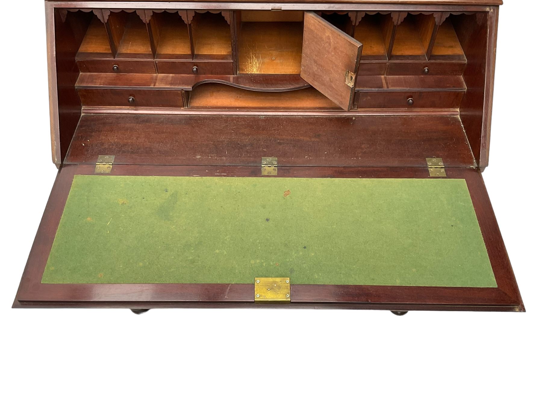 Early 19th century figured mahogany bureau bookcase, projecting splay moulded cornice over three adjustable shelves enclosed by two glazed doors, fall front revealing pigeonholes, cupboard and drawers, pull-out strays with scroll carved terminals, double cupboard with two panelled doors, on turned feet 
