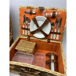  Two wicker picnic baskets, the largest by Optima and fitted for four people, the smaller unmarked and fitted for two, largest when closed H20cm L56 D38.  