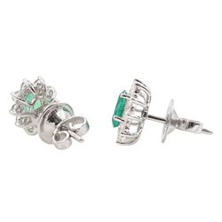 Pair of 18ct white gold oval emerald and round brilliant cut diamond cluster stud earrings, stamped, total emerald weight approx 0.90 carat, total diamond weight approx 0.55 carat