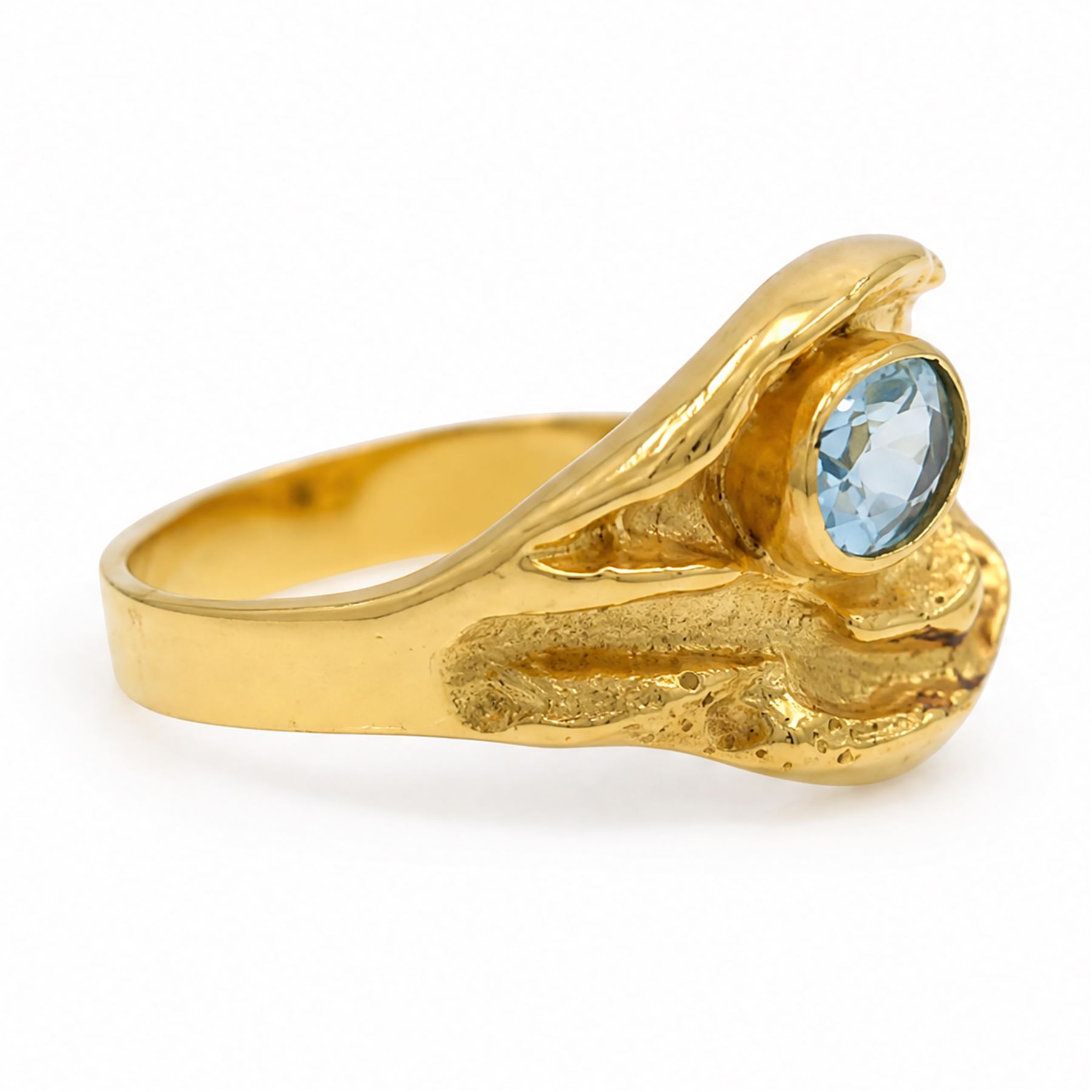 18ct gold Swiss blue topaz ring, bezel single oval cut topaz, within an abstract creased design setting, stamped 750