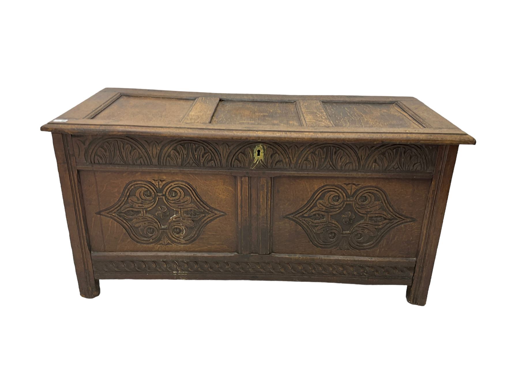 18th century oak blanket chest or coffer, rectangular hinged top with three panels and moulded edge, frieze carved with lunette and acanthus leaf decoration, two front panels carved with scrolling motif, raised on stile supports