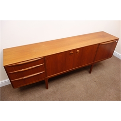  McIntosh teak retro sideboard, two cupboard doors enclosing fitted shelf flanked by three graduating drawers and a fall front unit with slide on tapering supports, W205cm, H75cm, D45cm  