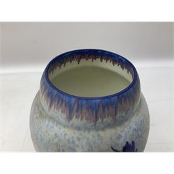 1930s Carlton Ware Art Deco Garden pattern vase of shouldered ovoid form, decorated with blue, pink and yellow flower heads on a mottled blue and white ground, pattern no. 3413, with printed and painted marks beneath, H19cm, together with a Clarice Cliff My Garden pattern vase, raised upon three feet with blue, pink and purple moulded Hollyhock design, H20cm, with Clarice Cliff Wilkinson Ltd England marks beneath