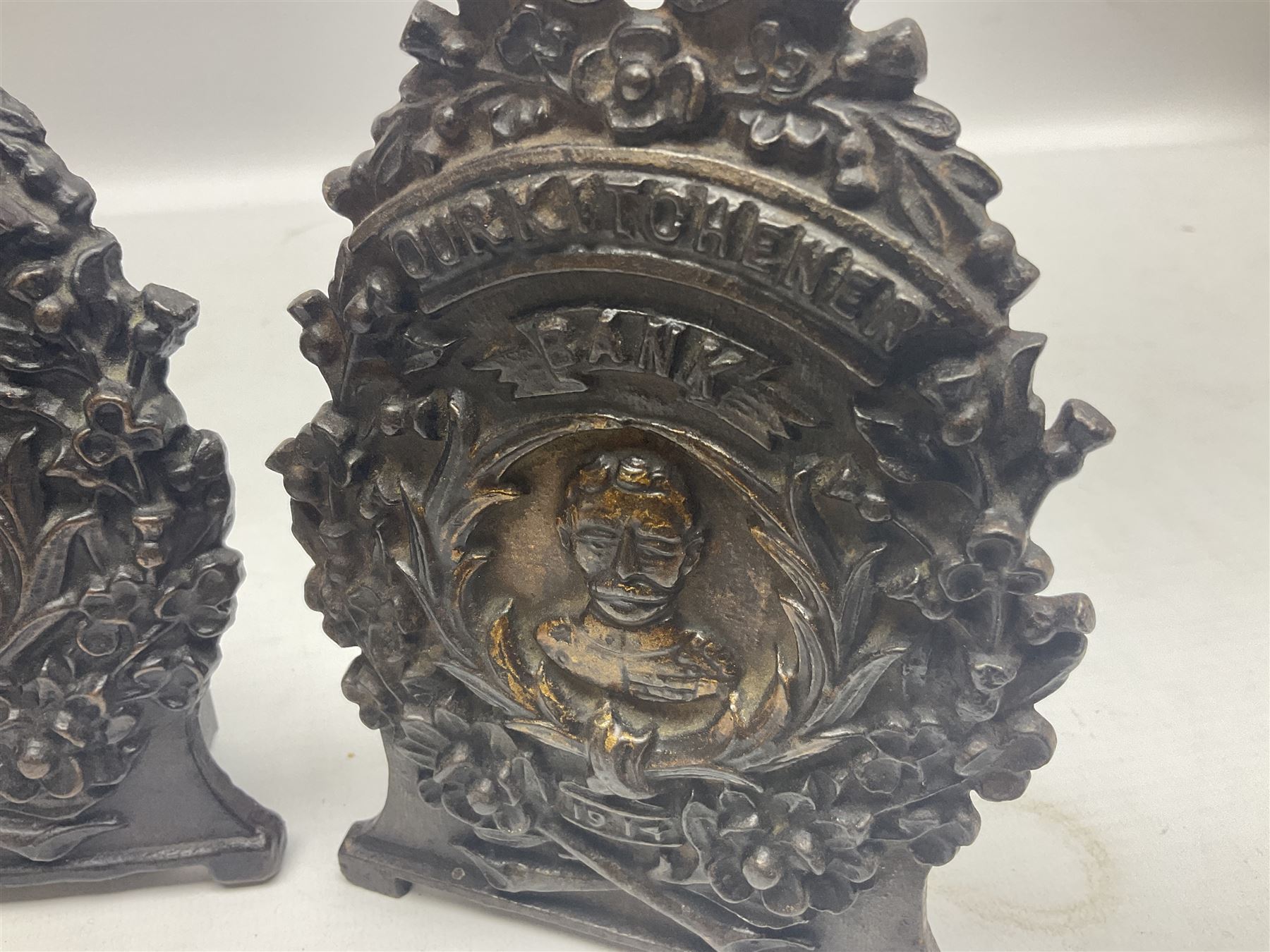 Two early 20th century cast-iron money banks - 'Our Kitchener Bank' c1914 H17cm and 'Our Empire Bank' c1911 depicting George V and Queen Mary H17cm; both by Sydenham & McCoustra; and another similar for The Prince & Princess of Wales 1981 by Robert Brown (3)