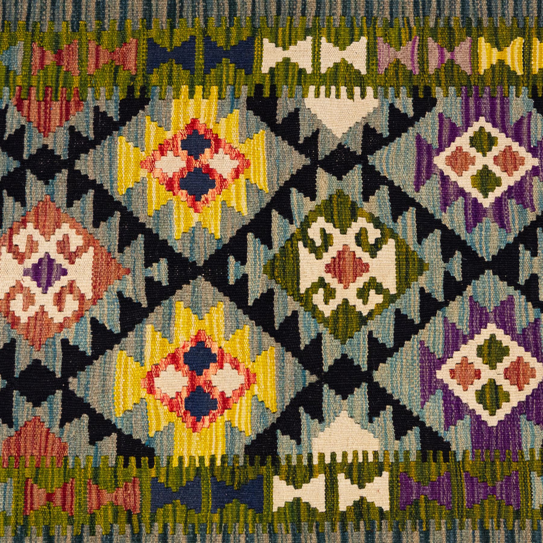 Afghan Maimana flatweave kilim, central field features large bold nested diamond motifs and stylized geometric lozenge patterns on olive purple, blue, and green tone ground, border stripe in blue tones, with fringe