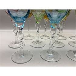 Ten coloured Adriana wine glasses by Abigails, to include blue, green, pink and yellow examples, each with part faceted bowl and twist stems, together with two similar orange examples with pulled stems, H24cm