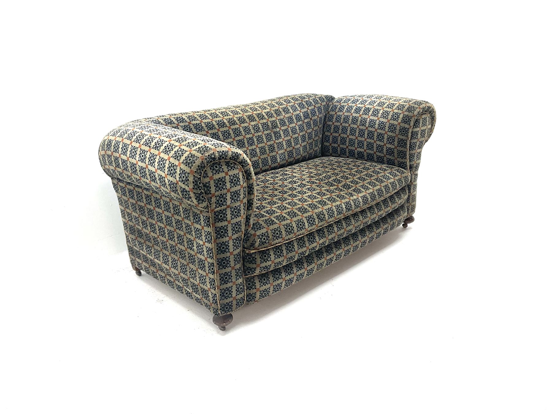 Early 20th century two seater drop arm sofa, upholstered in geometric pattern, turned supports and castors 