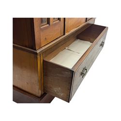 Victorian walnut bedroom suite - wardrobe, dressing chest and bedside cupboard, comprising a full-length wardrobe with broken pediment and central mirrored door, large lower drawer, a matching dressing table with bevelled swing mirror over two trinket drawers and two short drawers over two long drawers, and a single-door bedside cupboard, all with moulded edges, decorative panel work and shaped aprons