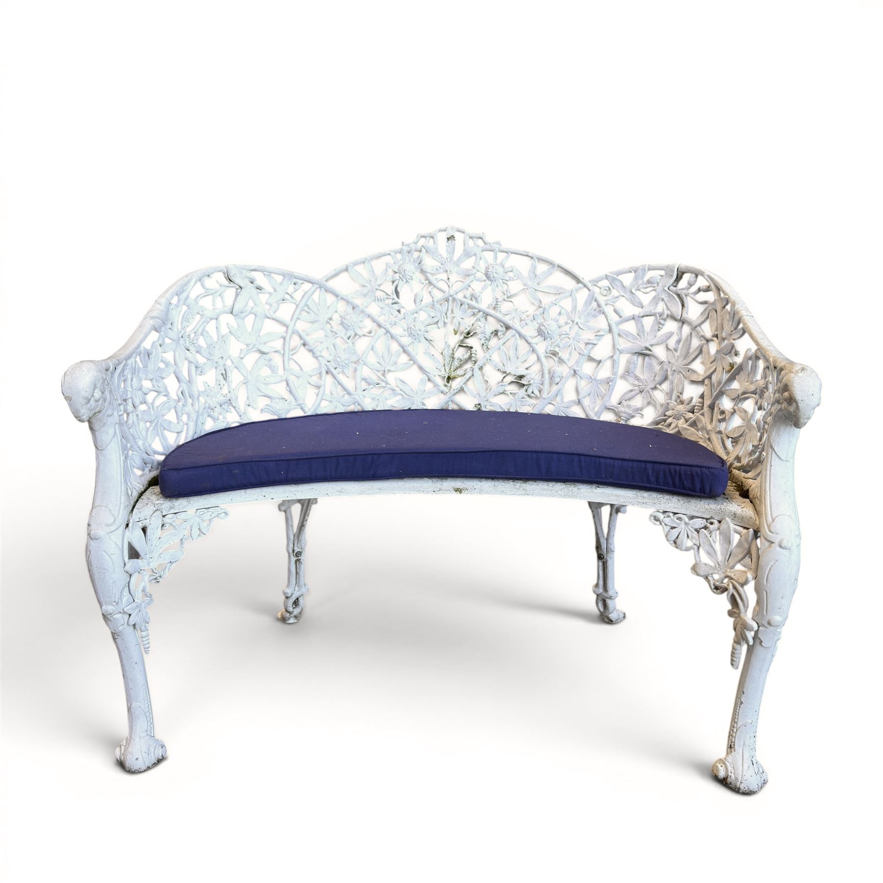 Victorian revival cast two seat garden bench, scrolling lattice back with flower heads, terminating to rams heads arms, curved pierced seat, finished in antique white paint