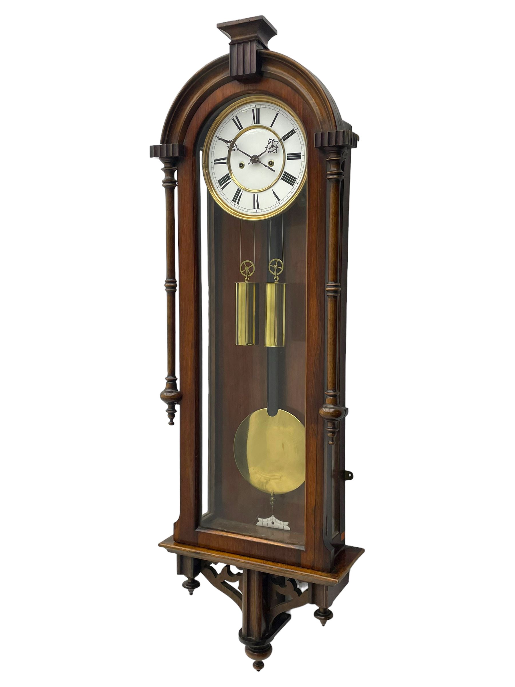 Lenzkirch – 8-day walnut cased weight driven Vienna regulator manufactured 1877-1878, with a break-arch pediment surmounted by a turned finial on a raised cavetto molding, fully glazed arched  door flanked by long ring turned pendants, flat base with open fretwork and two short pendants,  two piece enamel dial within a brass slip, Roman numerals, minute track and pierced steel hands, wooden pendulum with a brass faced bob, two brass cased weights and pulleys, dead beat escapement with a rack striking movement sounding the hours and half hours on a coiled gong, movement serial number 421410. 
Lenzkirch were one of Germanys most highly respected clock manufacturers of the 19th century, founded in the late 1850s the company produced movements and cases of high quality up until 1932.
