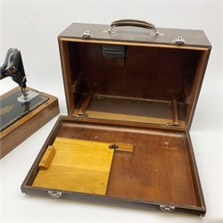 A vintage mid 20th Century cased Singer manual sewing machine, within faux crocodile carry case.