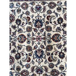 Northeastern Persian Meshed hand-knotted rug, ivory ground with an overall design of scrolling vines, palmettes, and rosettes in an indigo palette, soft blues, and madder, framed by a deep indigo border of lotus palmettes and flowerheads between multiple guard borders, 300cm x 202cm