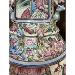Large pair of 19th century Cantonese famille rose vases, each painted with various courtly scenes, including a display of warriors fighting on horseback before an official and his attendants, double Buddhist lion handles and applied at the shoulders with chilong, the lower band painted with Greek key motif, H58cm (2)