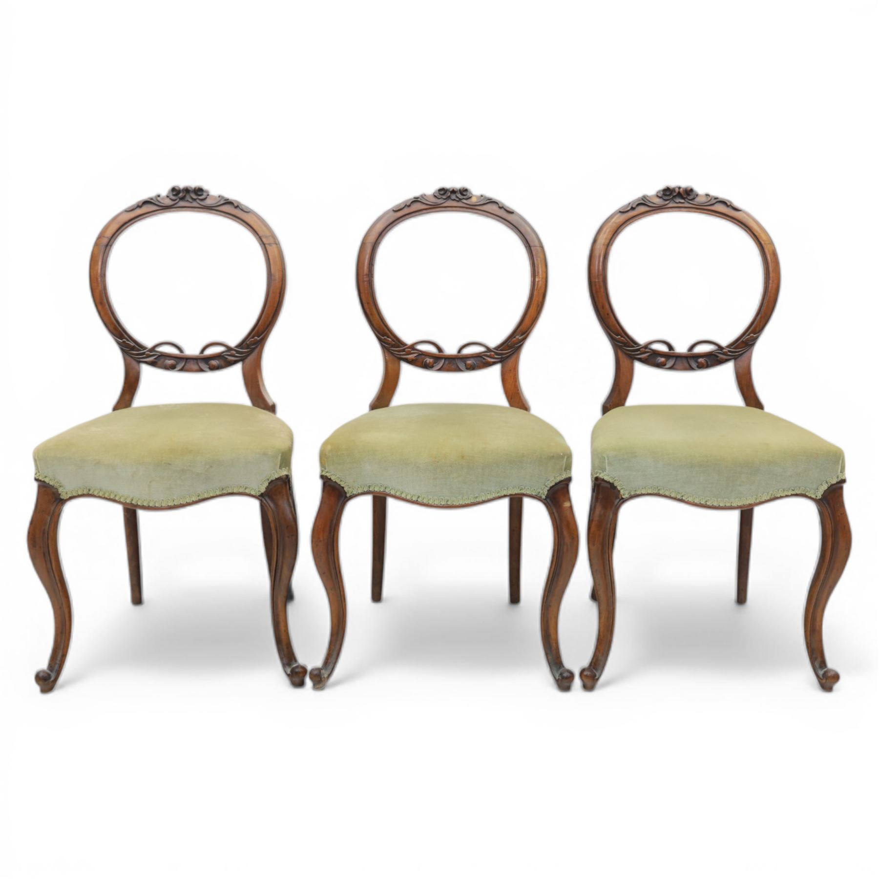 Victorian mahogany dining suite, oval tilt top dining table raised on a quatriform base with paw feet, together with a set of six balloon back dining chairs with green upholstery with cabriole legs 