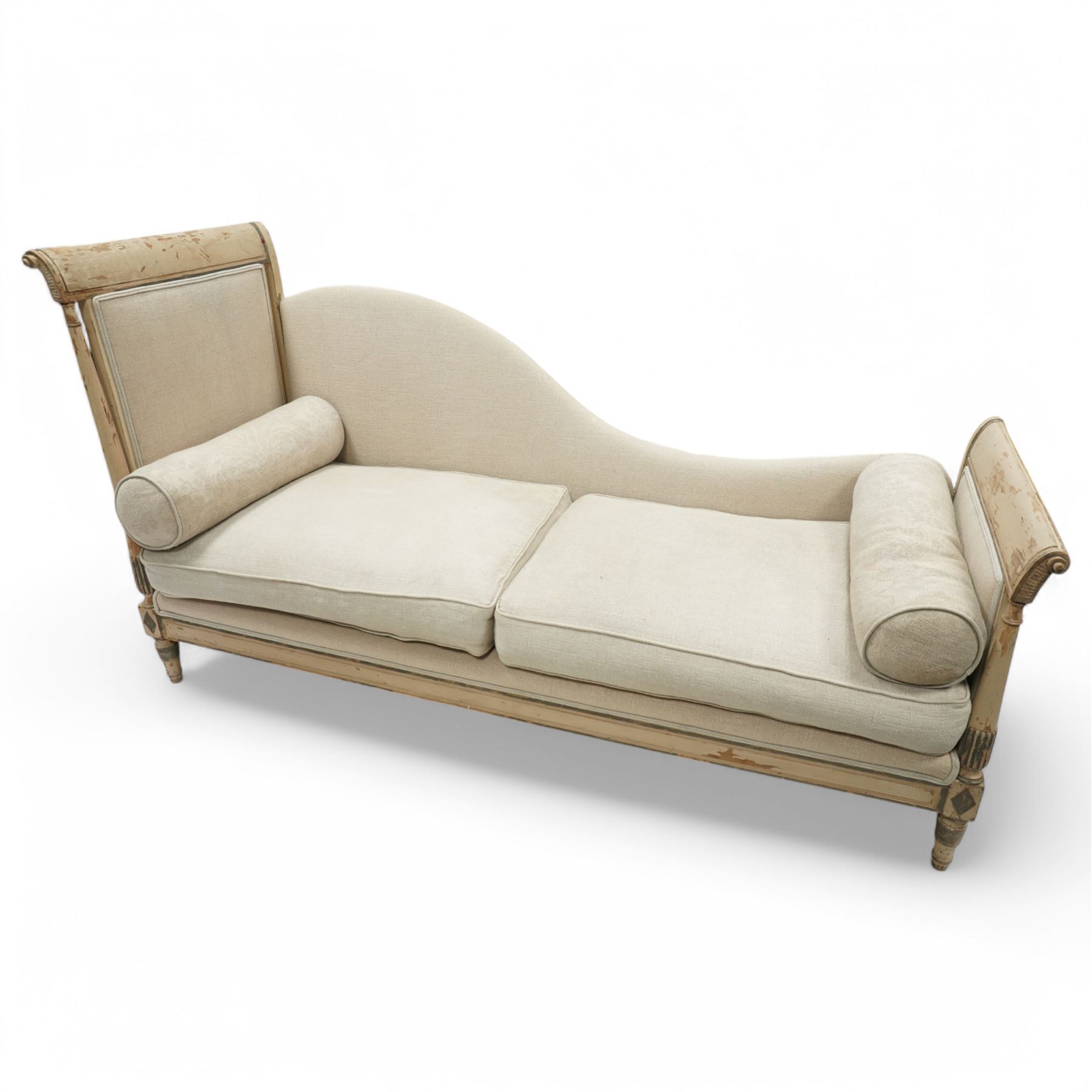 19th Century French day bed, the shaped back and scroll ends with fluted supports and carved rosettes, upholstered in natural linen with loose seat cushions and bolster pillows