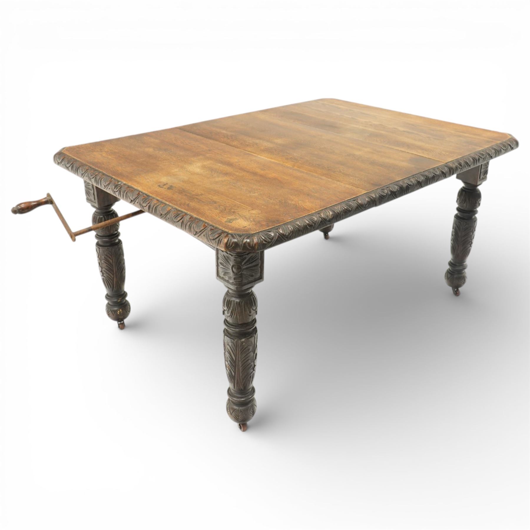 19th century heavily carved oak extending dining table, with winding mechanism and a gadrooned edge, over block and turned supports terminating in castors, extends to 147cm