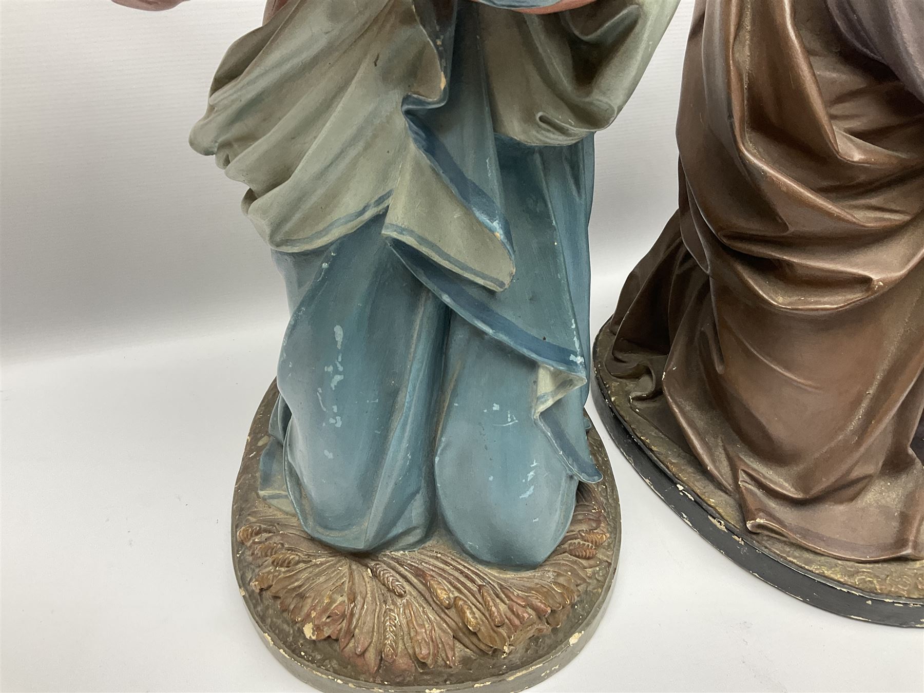 Two religious painted plaster figures of Mary and Joseph kneeling on oval plinths, with impressed mark 'Raffl et Cie Paris', H60cm 