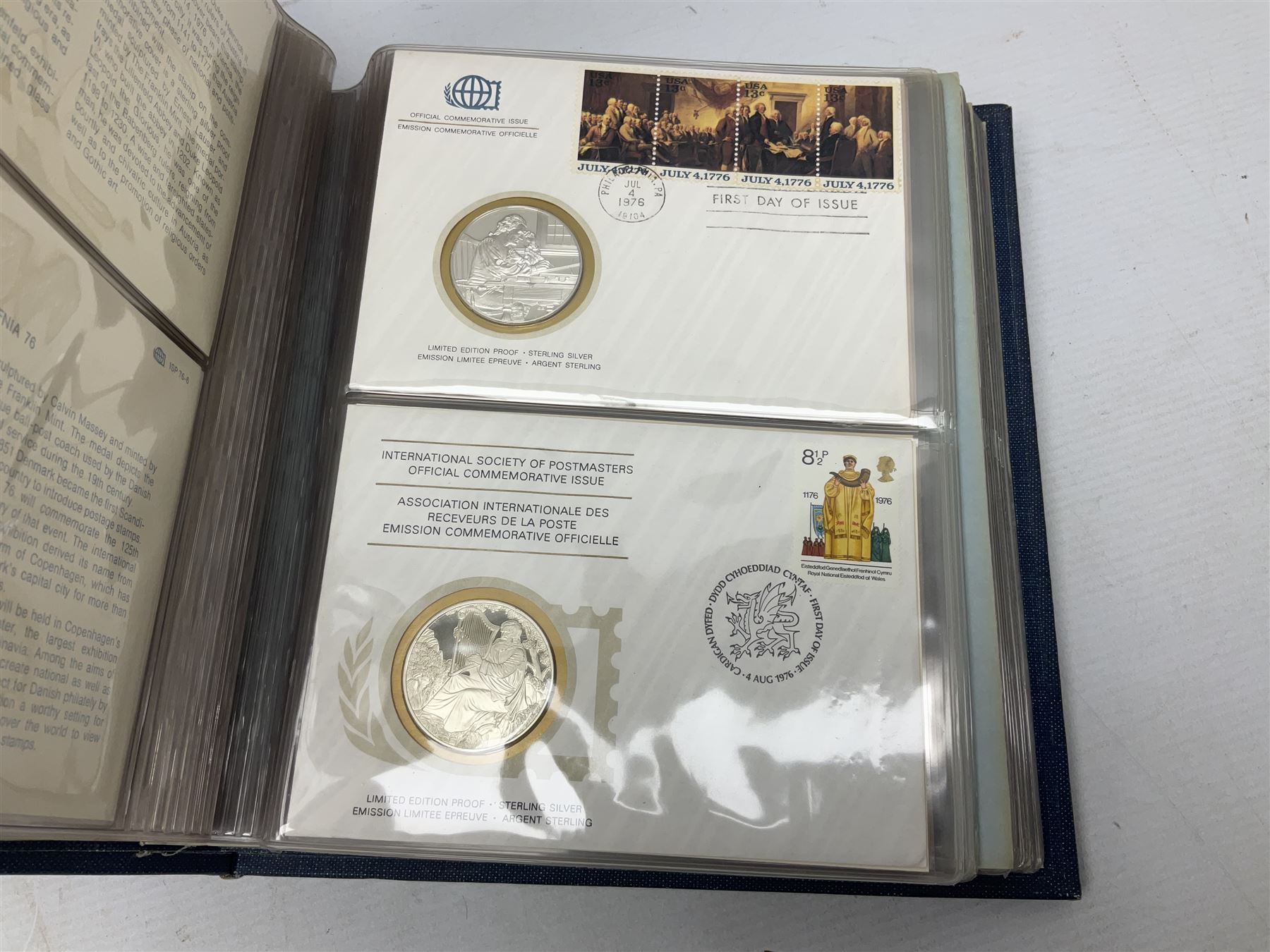 Thirty-six 'International Society of Postmasters Official Commemorative Issues' sterling silver proof medallic covers dating from 1975 to1977, housed in the official folder