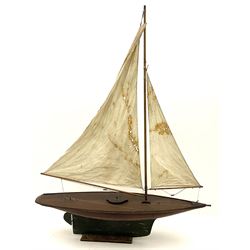 Large Victorian pond yacht, the planked hardwood hull with large lead weighted keel and working rudder, simulated planked deck and single mast with original sails; on later scratch-built wooden stand L117cm H151cm