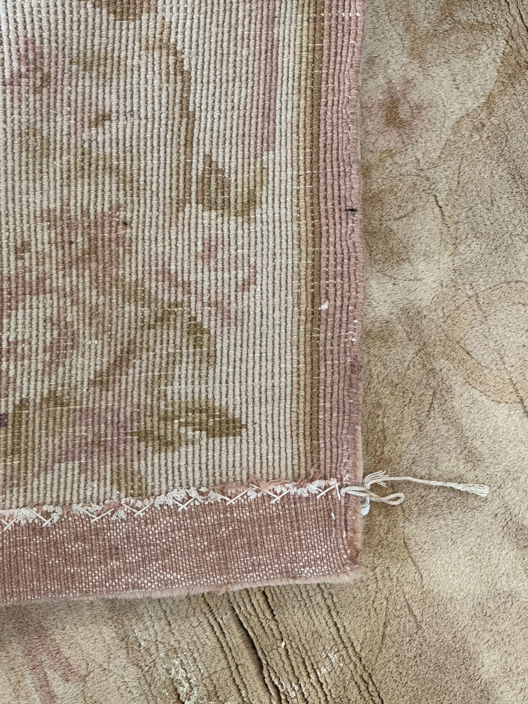 Chinese Savonnerie beige ground rug, central medallion surrounded by scrolling acanthus leaves and floral bouquets in soft pastel hues, wide border with floral garland and vine arrangement, the corners with floral sprays (198cm x 139cm); Chinese Savonnerie beige ground rug, oval central medallion, scrolling acanthus leaf and rose borders, wide band with floral garlands and rococo-design scrolls (198cm x 135cm)