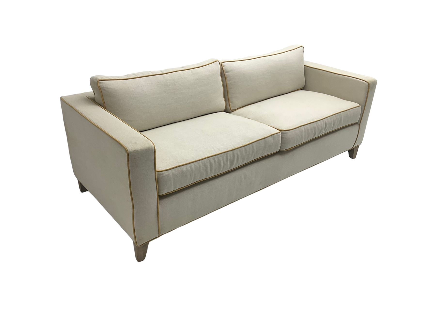 Neptune - pair three seat 'Shoreditch' sofas,  upholstered in cream fabric with yellow stringing