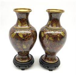 A pair of 20th century Japanese cloisonné vases, of baluster form decorated with flowers and foliage in tones of brown, with pierced wooden stands, not including stands H21cm.