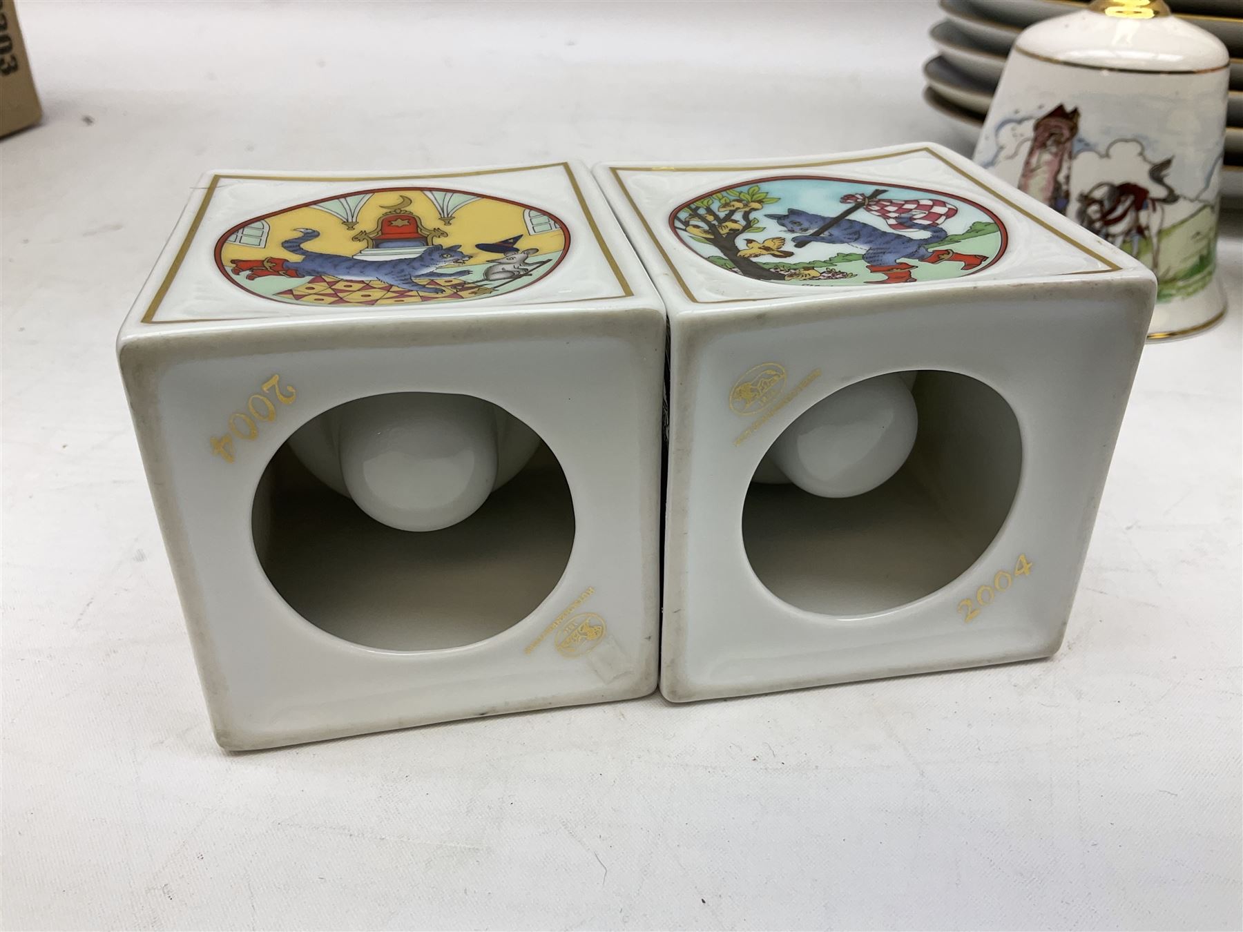 Royal Worcester Flower Fairies oval collectors plates, Goebel mustard pot, two Danbury Mint Fairy Tale bells, and pair of Hutschenreuther candlesticks decorated with scenes of Puss in Boots