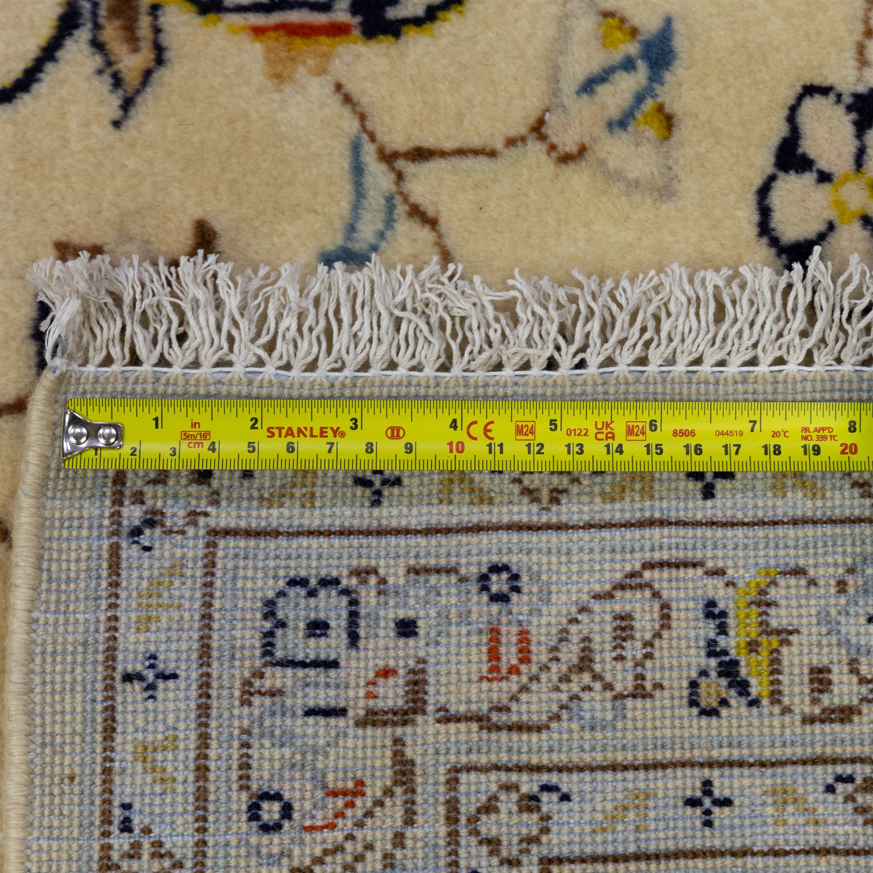 Central Persian Kashan hand-knotted carpet, ivory ground, with a central shaped floral medallion with pendants, surrounded by scrolling foliate and floral motifs incorporating rosettes, palmettes and delicate vine work, enclosed by a conforming ivory border with repeating palmettes and meandering vines, flanked by floral guard stripes, with cotton fringes