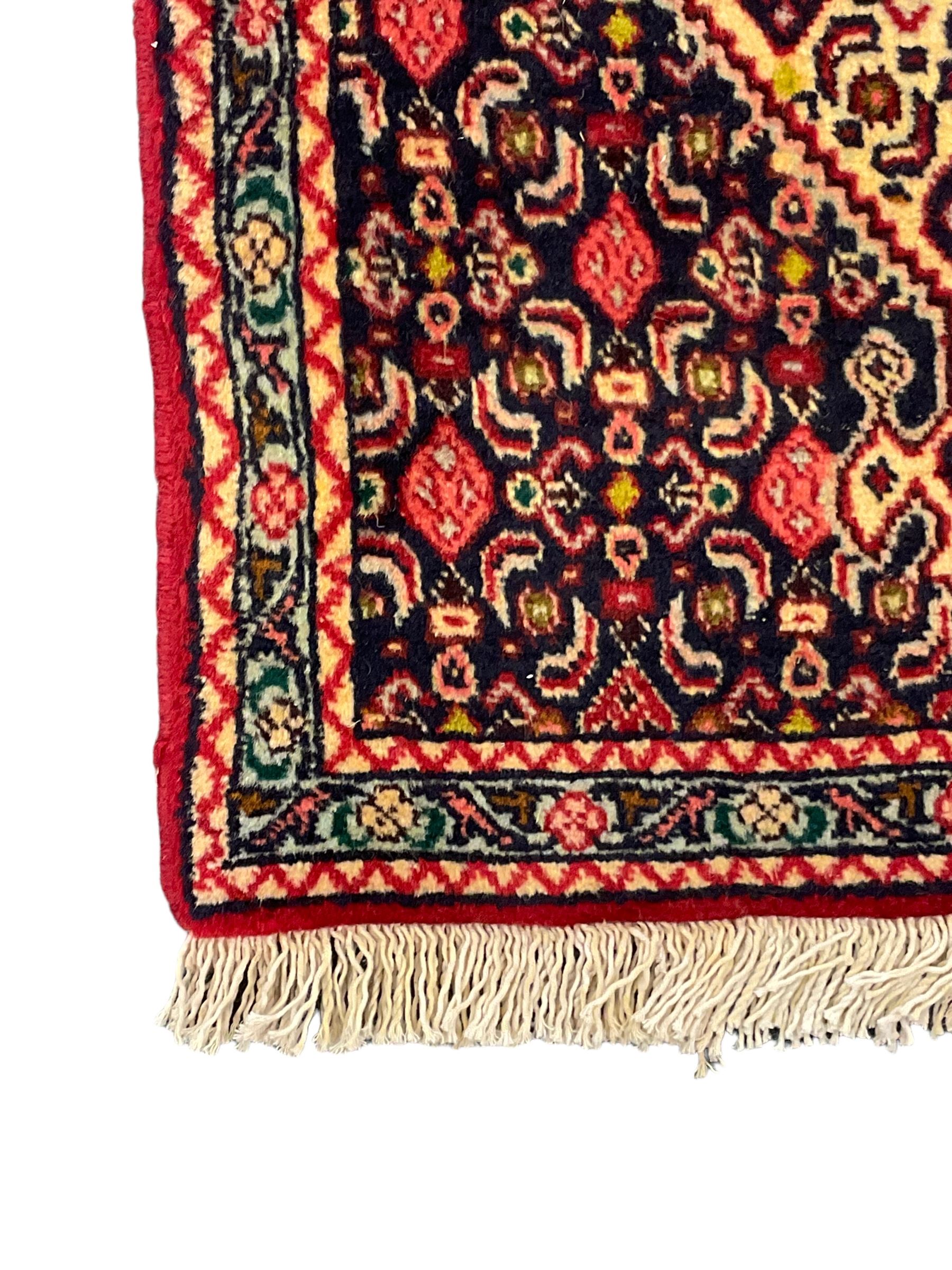 North West Persian Senneh indigo and crimson ground runner, the Herati decorated field with five interconnected lozenges, triple band border with repeating flower head motifs 