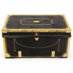 An early 19th-century Georgian brass-bound travelling trunk, leather-covered exterior with brass stud work decoration, front with central brass lock plate, hinged lid with camphor wood interior, external sides fitted with large brass carrying handles 