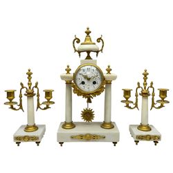 French - Late 19th century 8-day white marble and gilt metal portico clock garniture, the clock surmounted by an urn and raised on a pair of cylindrical pillars above a rectangular plinth base, white enamel dial with Arabic numerals and floral garlands, twin train countwheel striking movement, striking the hours and half hours on a bell, with a sunburst pendulum and gilt Louis XVI hands, garniture with matching twin light candelabra. With Key.   Candelabra H 30cm.