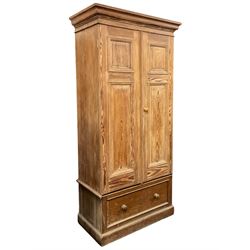 Victorian pitch pine double wardrobe, projecting moulded cornice over two panelled doors, the interior fitted with hanging rail and hooks, single drawer to base