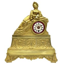 A Napoleon III c1860 French Ormolu mantle clock with a reclining figure of an oriental lady on a stepped plinth, base with splayed feet and raised decoration comprising scroll work and acanthus leaves, with a white and rouge enamel dial with hand painted floral decoration, roman numerals, minute track and brass spade hands, eight-day timepiece movement with pendulum.

